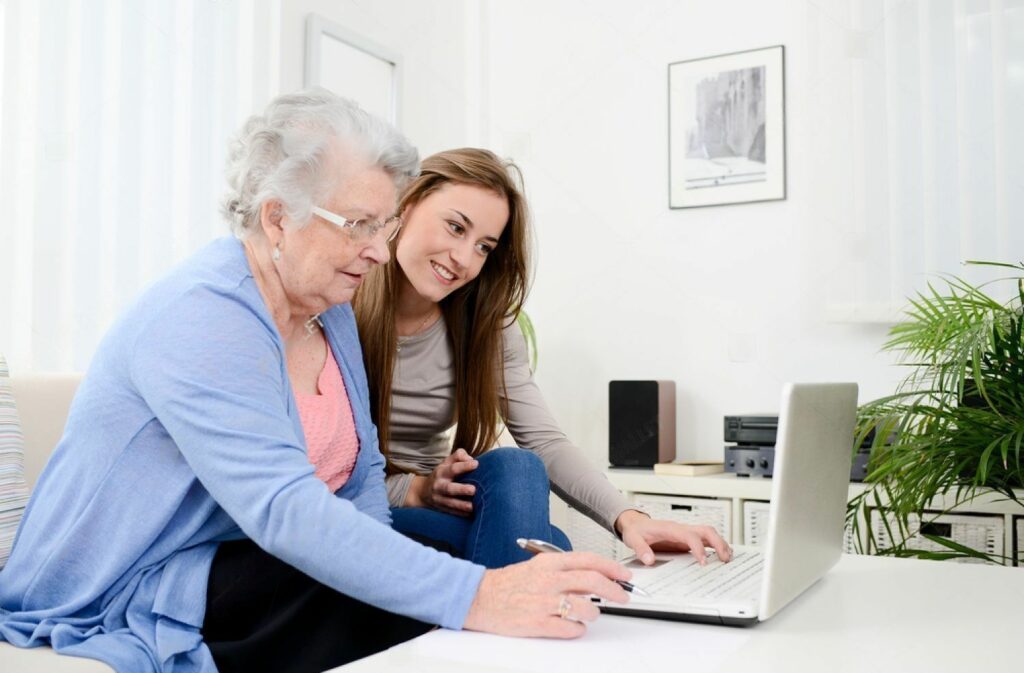 Female Elderly Person with a young woman looking at a laptop screen